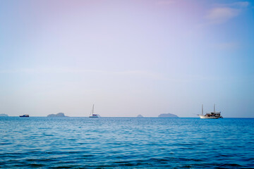 The vast sea with boats floating in the middle of the sea, the bright blue sea, the blue sea background.