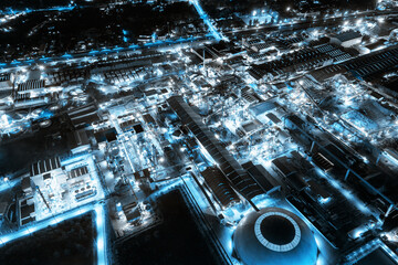 Blue light industrial factory with chemical refinery and building material glowing light at night