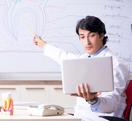 The young handsome dentist in front of the whiteboard