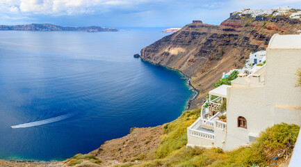 Picturesque view of the famous Greek resort of Thira, Santorini island. Traditional village with white houses with blue domes over Caldera, Aegean Sea. Greece. Summer holidays.