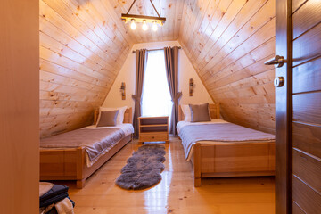 Interior of a wooden mountain house attic two bed bedroom