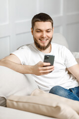 young man at home on the couch talking video call from the phone.
