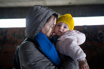 Loving mother holding her child in the bomb shelter - obrazy, fototapety, plakaty