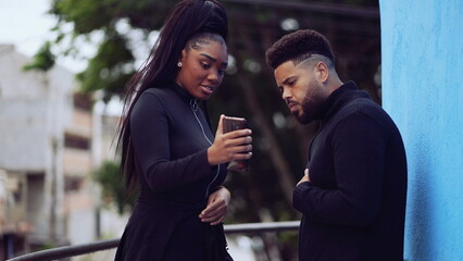 Two people looking at phone screen person showing content online