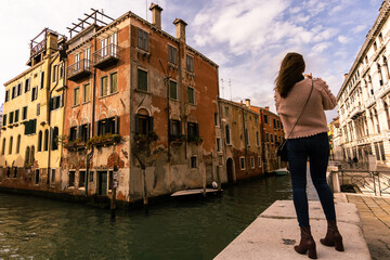 Fototapeta na wymiar Venice Italy. November 20 2021. Tourist woman taking picture with mobile phone to the canals of Venice