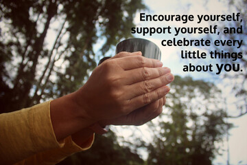 Inspirational motivational quote - Encourage yourself, support yourself, and celebrate every little things about you. With person holding cup of morning tea or coffee in hands. Self love care concept.