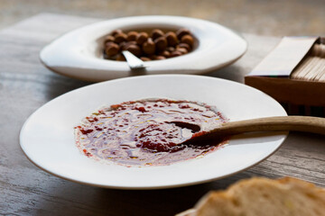 plate of crushed tomato with a wooden spoon