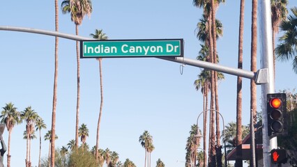 Palm trees and blue sky, Palm Springs resort city near Los Angeles, street road sign, semaphore traffic lights on crossroad. California desert valley summer road trip on car, travel USA. Indian Canyon