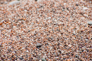 Small sea pebbles with stones with a reddish tint