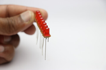 Red LED on an empty circuit board arranged in parallel circuit connection. Young inventor working...