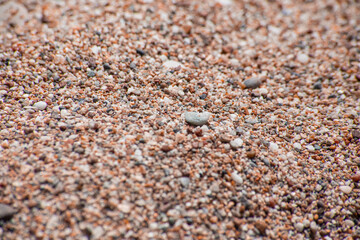 Small sea pebbles with stones with a reddish tint