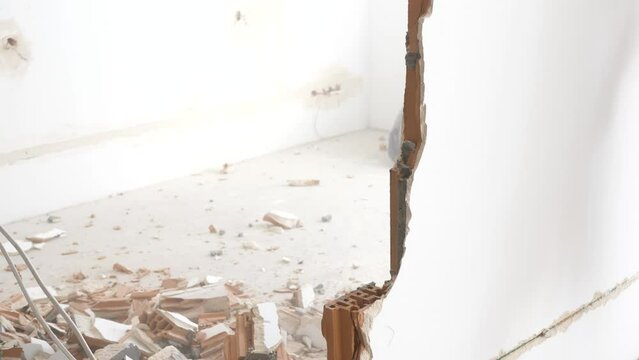 Man hitting a brick wall with a hammer, wall demolition