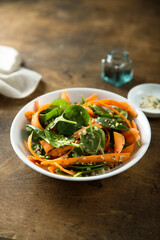 Healthy homemade spinach salad with carrot and sprouts