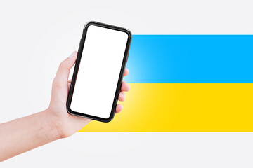 Smartphone with mockup in hand on background of white and Ukraine flag.