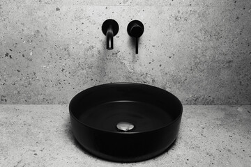 Photo of bathroom details: black round washbasin and mounted tap.
