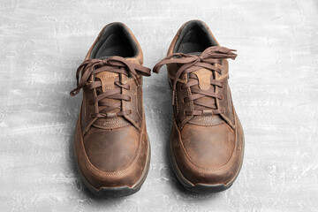 Mens brown leather walking shoes on textured background