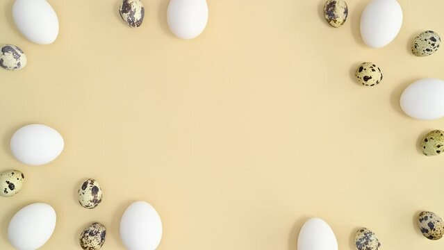Creative copy space with white and quail eggs make frame on pastel beige background. Stop motion flat lay