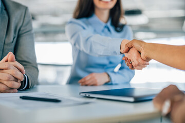 Close-up photo of two female colleagues shaking hands. - obrazy, fototapety, plakaty