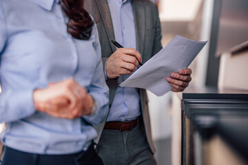 Closeup picture of caucasian man, signing a document, standing w