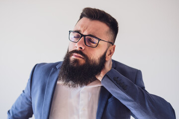 Portrait of businessman who is having pain in his neck. Copy space on image for your text or advert.