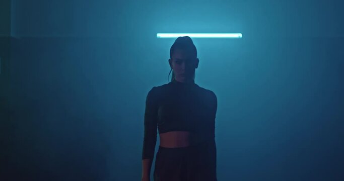 Young woman exits their smoke, dark room of a fight club. Silhouette of an athlete in a dark room of the gym, the girl goes to fight. 4k, ProRes