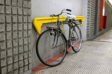 Fototapeta na wymiar evocative image of a man's bicycle tied to a subway rail from Milan 