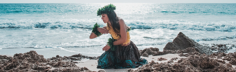 Hawaiian woman smiles relaxed on a paradise beach. Exotic beauty with flower crown on her head.