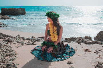 Hawaii dancer. Hula dancer woman unrecognizable on the beach sitting on her knees. Hawaiian woman smiles relaxed on a paradise beach. Exotic beauty with flower crown on her head. - obrazy, fototapety, plakaty