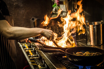A Chinese food cook is cooking.
