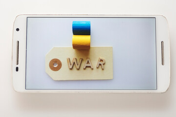 Smartphone with the label war and the colors of the ukrainian flag. Blue and yellow. 