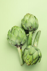 Fototapeta premium Concept of healthy food with artichoke on green background