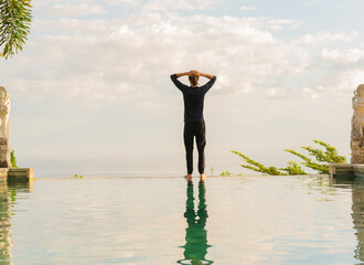 A man standing at the edge of infinity pool