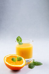 Orange juice in glasses and fresh oranges on a gray background. Concept. Photo