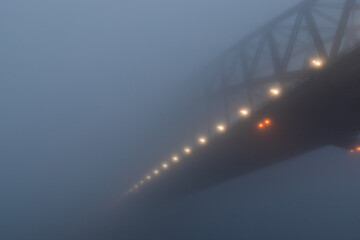 Thick fog covering Sydney Harbour Bridge in the morning.
