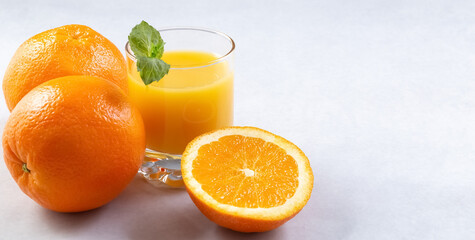 Orange juice in glasses and fresh oranges on a gray background. Banner. Photo
