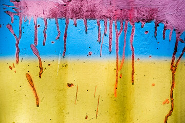 Ukrainian flag painted on a wall. Yellow blue wall texture background. Grunge yellow blue wall background with red blood paint. Abstract grunge background.