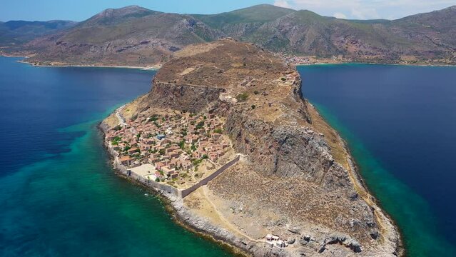 Aerial drone video of beautiful castle and medieval old city of Monemvasia in the heart of Lakonia with beautiful clouds and deep blue sky, Peloponnese, Greece
