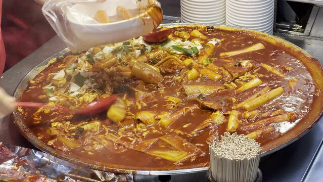 mixing tteokbokki big pan korean street food spicy red  busan market street, 4k 