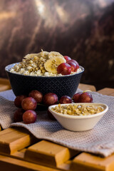 A plate of cottage cheese with granola, muesli, oatmeal, grapes and banana. Protein diet breakfast. Healthy and delicious food for breakfast. High quality photo