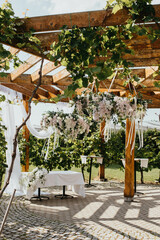 Wedding. Banquet. Chairs and honeymooners table decorated with candles. Beautiful decoration, beautiful flowers.