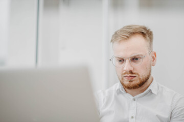 portrait of a young successful man of European appearance, a businessman in a white shirt. Intellectual activity.