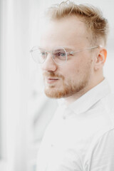 portrait of a young successful man of European appearance, a businessman in a white shirt. Intellectual activity.