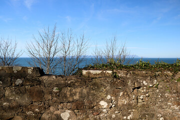 View of Isle of Arran in Scotland Over an Ancient Stone Wall