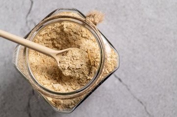 nutritional yeast in flakes, deactivated, not live, B vitamins, in a jar, focus on a spoon, close-up, top view