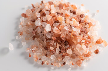 Fototapeta na wymiar pink Himalayan coarse salt on a white background, close-up, top view