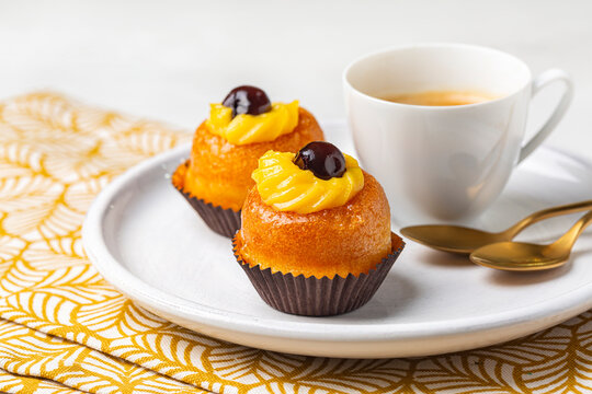 A rum baba or baba au rhum, small yeast cake saturated in syrup made with hard liquor, with custard cream and black cherries and espresso coffee.  Italian pastry.