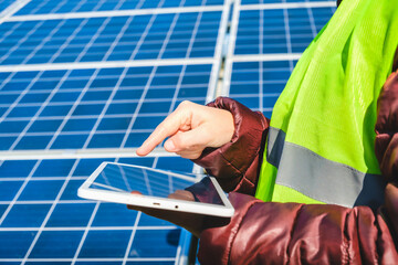 engineering use a tablet working on roof checking and maintenance in solar power plant , solar...