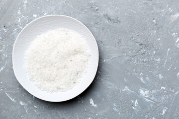 A wooden bowl of salt crystals on a wooden background. Salt in rustic bowls, top view with copy space