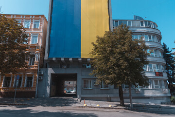 The national flag of Ukraine flutters in the wind. The national symbol of the Ukrainian people on the building. City Dnipro