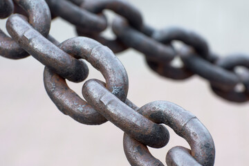 Old iron anchor chain. Rusty chain links defocused diagonally. Simple background.